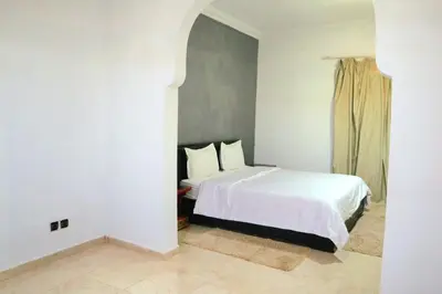 a bedroom with a white bed and a window at Gîte AYA in Marrakech