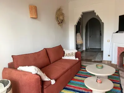 a living room with a brown couch and two tables at Appartement dans la palmeraie in Marrakech