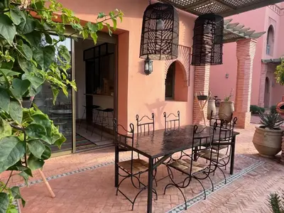 a table and chairs on the patio of a house at Appartement dans la palmeraie in Marrakech