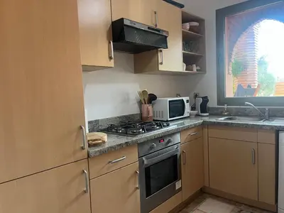a kitchen with a stove and a microwave at Appartement dans la palmeraie in Marrakech