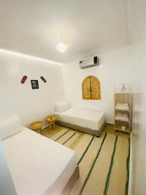 a white room with two beds and a couch at riad dar wlidati in Marrakech