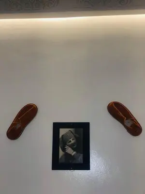 a picture of two wooden shoes on a wall at riad dar wlidati in Marrakech