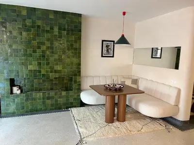 a living room with a table and a green wall at Appartement Élégant et Spacieux Près de Carré Eden in Marrakech