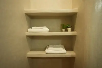 two towels are sitting on shelves in a bathroom at Romantic getaway heart of Gueliz in Marrakech