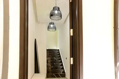 a hallway with two pendant lights and a staircase at Superbe Duplex piscine chauffée in Marrakech