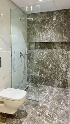 a bathroom with a toilet and a glass shower at Superbe Duplex piscine chauffée in Marrakech