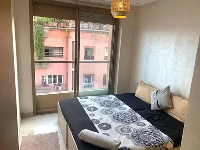 a bed in a room with a large window at 2-Bedroom Apart, Heart of Gueliz in Marrakech