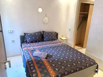 a bedroom with a bed with a blue comforter at 2-Bedroom Apart, Heart of Gueliz in Marrakech