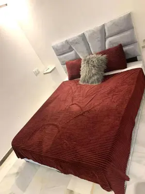 a large bed with a red blanket and pillows at 2-Bedroom Apart, Heart of Gueliz in Marrakech