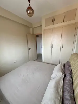a bedroom with a large white bed and cabinets at Location Familiale Marrakech 2 in Marrakech