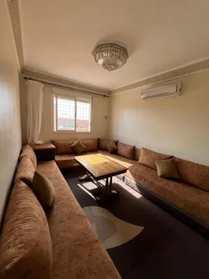 a living room with a large couch and a table at Location Familiale Marrakech 2 in Marrakech