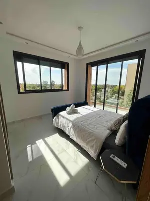 a bedroom with a bed and a couch and windows at Luxueuse villa au Golf Amelkis - 5 suites in Marrakech