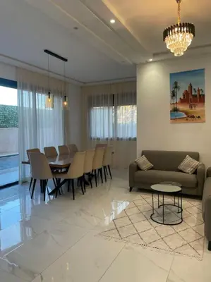 a living room with a couch and a table and chairs at Luxueuse villa au Golf Amelkis - 5 suites in Marrakech