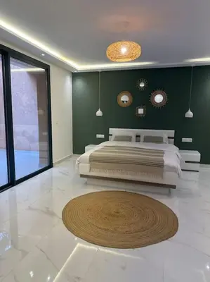 a bedroom with a bed and a circular rug on the floor at Luxueuse villa au Golf Amelkis - 5 suites in Marrakech