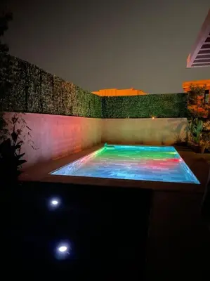 a pool with a rainbow colored water in a room at Luxueuse villa au Golf Amelkis - 5 suites in Marrakech