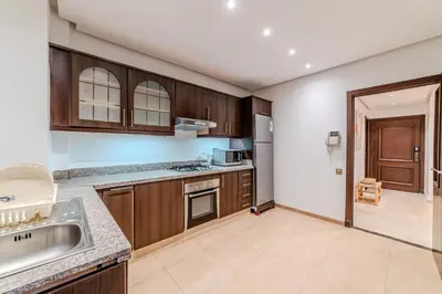 a kitchen with wooden cabinets and a sink at Luxury Apartment 3 Bedroom in CityCenter Marrakech in Marrakech