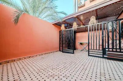 a balcony with a gate and a palm tree at Luxury Apartment 3 Bedroom in CityCenter Marrakech in Marrakech