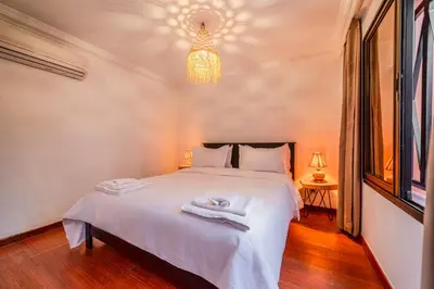 a bedroom with a large white bed with a chandelier at Luxury Apartment 3 Bedroom in CityCenter Marrakech in Marrakech