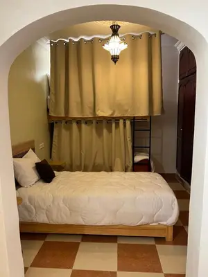 a bedroom with a bed with a curtain and a chandelier at Habibi Riad&Hostel in Marrakech