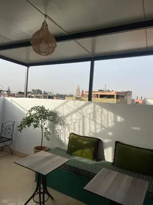 a balcony with a table and chairs and a window at Habibi Riad&Hostel in Marrakech