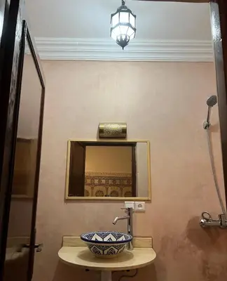 a bathroom with a mirror and a bowl on a table at Habibi Riad&Hostel in Marrakech