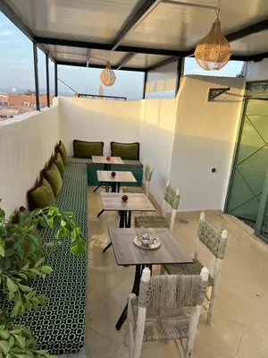 a patio with tables and chairs on a roof at Habibi Riad&Hostel in Marrakech
