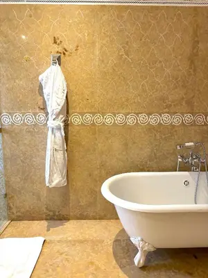 a bathroom with a bath tub and a white bath tub at Palais Mars in Marrakech
