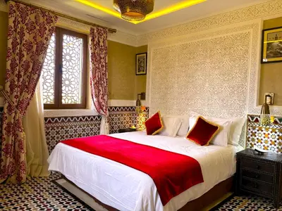 a bedroom with a large bed with a red blanket at Palais Mars in Marrakech