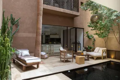 a living room with a table and chairs and a pool at Riad 17 DAR CHAMAR in Marrakech
