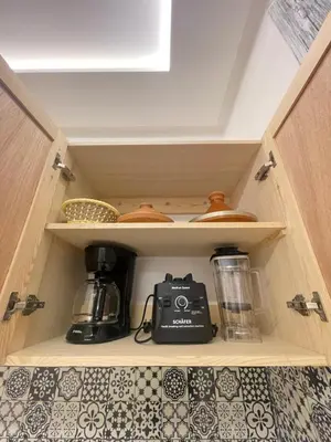a kitchen cabinet with a tea maker and a blender at cosy appartement a marrakech in Marrakech