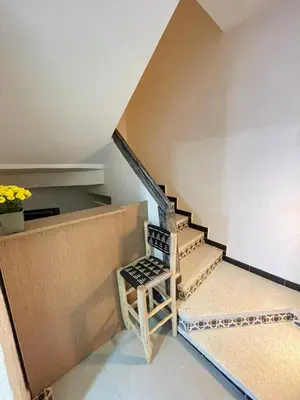 a chair sitting next to a staircase in a house at cosy appartement a marrakech in Marrakech