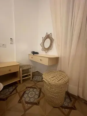 a bathroom with a vanity with a mirror and a stool at cosy appartement a marrakech in Marrakech