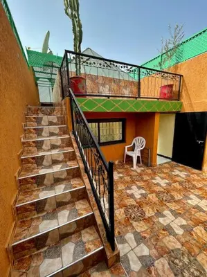 a staircase leading up to a building with a chair at Riad mostafa in Marrakech