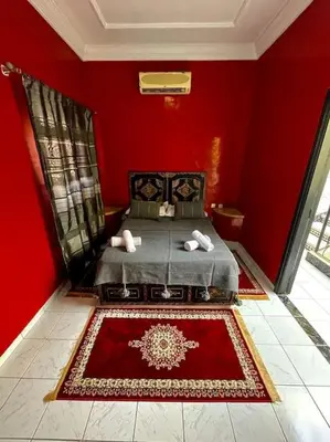 a red bedroom with a bed with a red wall at Riad mostafa in Marrakech