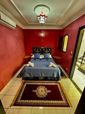 a bedroom with a bed in a red wall at Riad mostafa in Marrakech