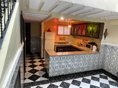 a kitchen with a black and white checkered floor at Riad mostafa in Marrakech
