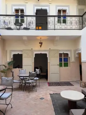 a patio with tables and chairs and a balcony at Riad Lou Kasbah in Marrakech