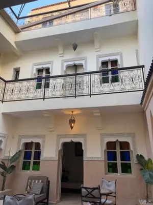 a large white building with a balcony and chairs at Riad Lou Kasbah in Marrakech