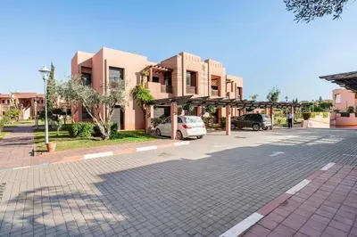 a parking lot with cars parked in front of a building at Marrakech flat with swimming pool & sunny garden in Marrakech