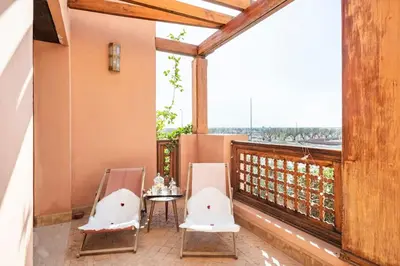 a balcony with two chairs and a table with a view at Marrakech flat with swimming pool & sunny garden in Marrakech