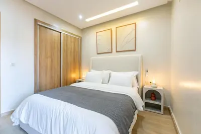 a bedroom with a large white bed with two lamps at Chic urbain en plein centre in Marrakech