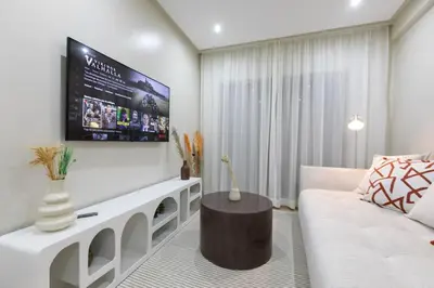 a living room with a white couch and a flat screen tv at Chic urbain en plein centre in Marrakech