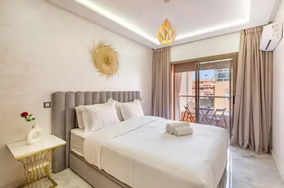 a bedroom with a large bed and a balcony at appt élégant et confort dans le centre de Marrakech in Marrakech