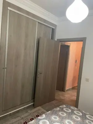 a room with wooden cabinets and a bed with a rug at Appart in Marrakech 5G in Marrakech