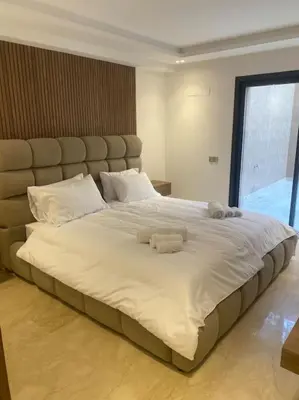a large white bed with two stuffed animals on it at Sublime Villa avec Ascenseur Piscine chauffée in Marrakech