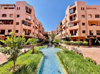 a fountain in a courtyard in front of some buildings at Cosy Apartment with 5 pools in Marrakech
