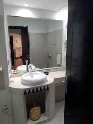 a bathroom with two sinks and a large mirror at Cosy Apartment with 5 pools in Marrakech