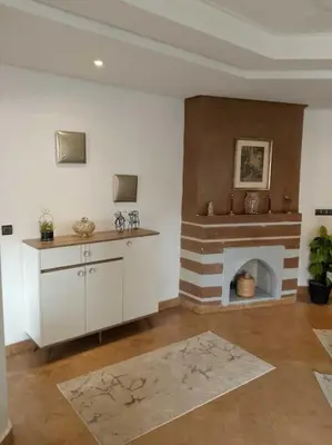 a living room with a fireplace and a room with a table at Cosy Apartment with 5 pools in Marrakech