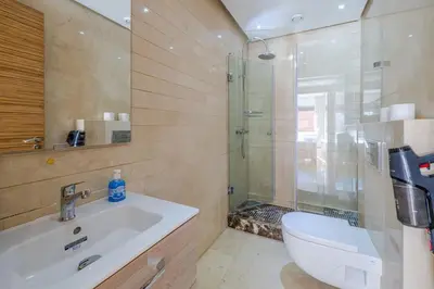 a bathroom with a sink and a shower and a toilet at Best location new appart café de la poste Plaza in Marrakech