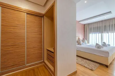 a bedroom with a bed and a walk in closet at Best location new appart café de la poste Plaza in Marrakech